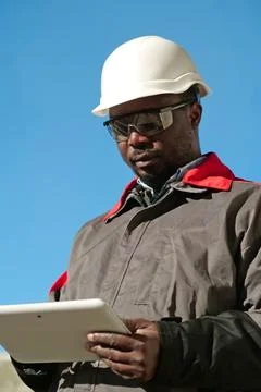 African american worker with tablet computer stands at construction site Stock Photos