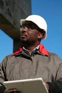 African american worker with tablet computer stands at construction site Stock Photos
