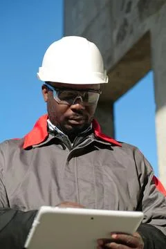 African american worker with tablet computer stands at construction site Stock Photos