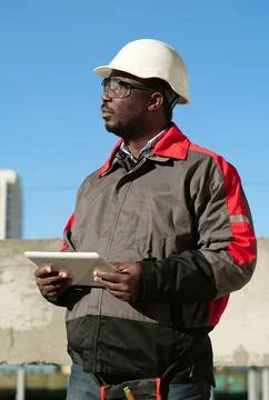 African american worker with tablet computer stands at construction site Stock Photos