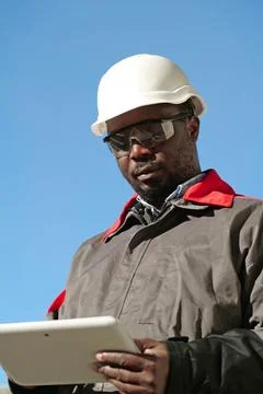 African american worker with tablet computer stands at construction site Stock Photos