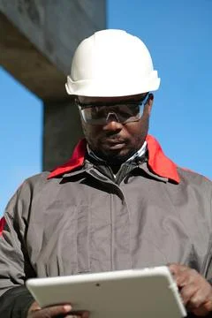 African american worker with tablet computer stands at construction site Stock Photos
