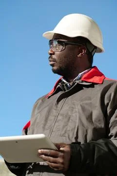 African american worker with tablet computer stands at construction site Stock Photos