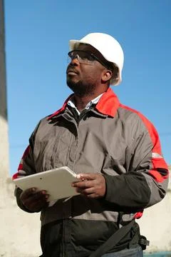 African american worker with tablet computer stands at construction site Stock Photos