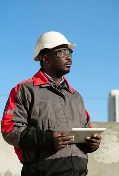 African american worker with tablet computer stands at construction site Stock Photos