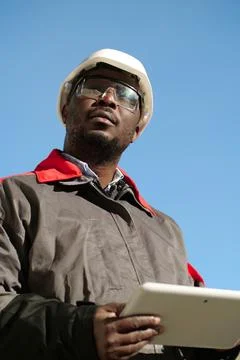 African american worker with tablet computer stands at construction site Stock Photos