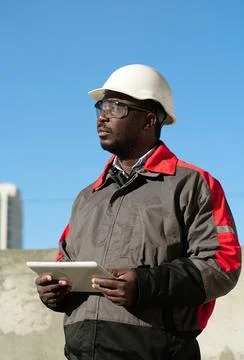 African american worker with tablet computer stands at construction site Stock Photos