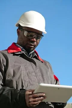African american worker with tablet computer stands at construction site Stock Photos