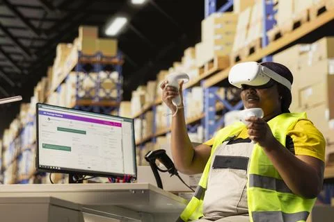 African American worker using VR headset to consult tracking info on software Foto stock