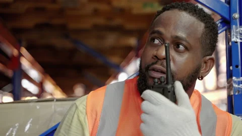 African American worker using walkie talkies in warehouse Stock Footage 224708384