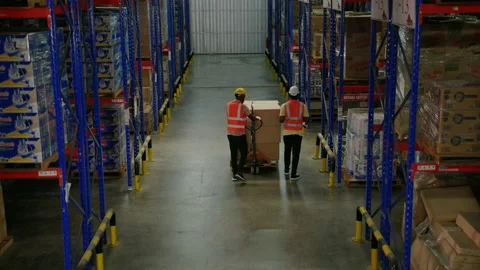 African American worker in a warehouse is using a cart to load boxes 스톡 동영상 223383010