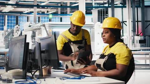 African american workers checking up on manufacturing equipment Stock Footage 309075690