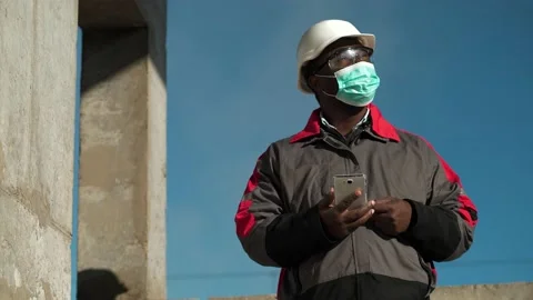 African american workman in mask talks on smartphone by video link Stock Footage 199290844