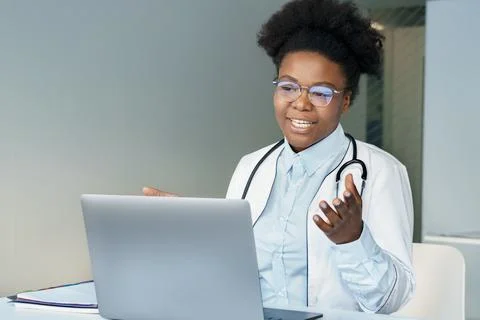 African american young female doctor consulting patient online using laptop Stock Photos