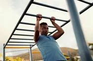 African American Young Man Exercising On Monkey Bars For The Upper-Body In A Stock Photos