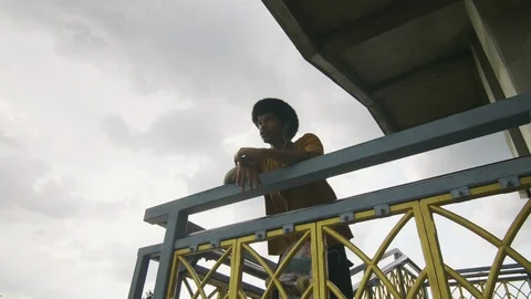 African American young man in yellow t shirt listening to music on stairs Stock Footage 99956953