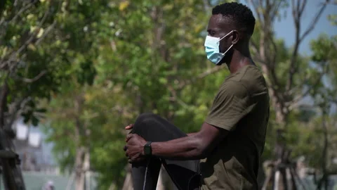 African american young runner man wearing surgical face mask stretching leg w Stock Footage 146652676