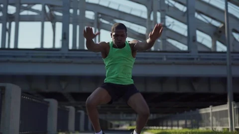African athlete doing frog squat jumps Stock Footage 117063901