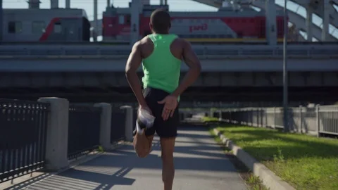 African athlete practicing butt kicks exercise Stock Footage 117062441