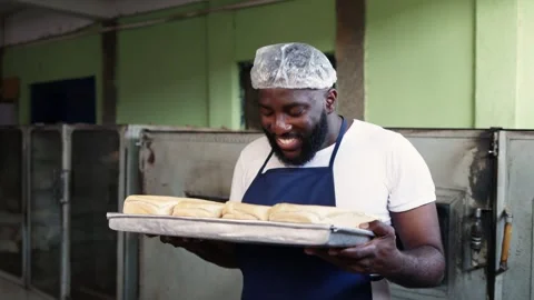 African baker enjoys aroma of fresh bread with satisfaction, proud SME Stock-Footage 346565341