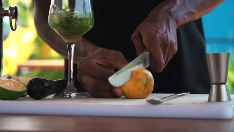 African bartender cutting passion fruit and making mojito cocktail, slow motion Stock Footage 230080358
