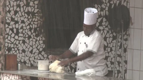 African black chef preparing dough for cooking under heavy rain 스톡 동영상 58994209