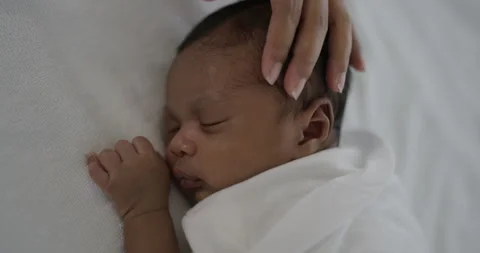 African black parent hands pad on newborn baby head Stock Footage 336795325