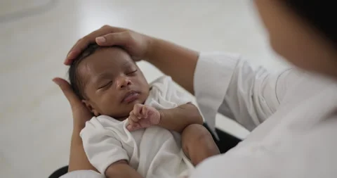 African black parent hands pad on newborn baby head Stock Footage 340309482