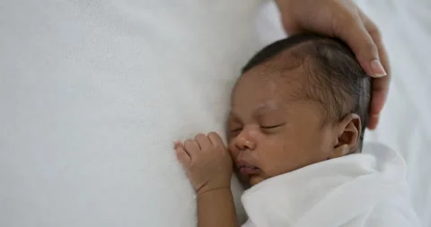 African black parent hands pad on newborn baby head Stock Footage 340365389