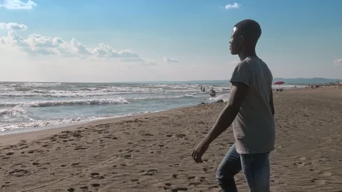 African Black young man walking toward the sea. Migration,Africa, missing home Stock Footage