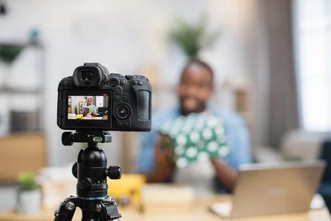 African blogger unpacking gift boxes during live stream 스톡 사진