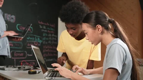 African boy point at laptop screen while cute girl type laptop. Edification Stock Footage 274452963