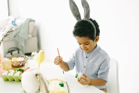 African boy is preparing for Easter at table Stock Photos