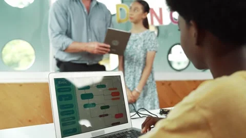 African boy programming system while girl ask and point at tablet. Edification Stock Footage 283222881