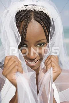 African bride pulling veil forward Stock Photos