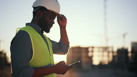 African builder with smartphone, man using mobile app during work day, portrait Stock Footage 318709873
