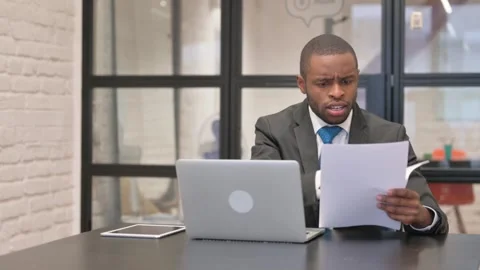 African Businessman Feeling Upset while Working on Documents and Laptop Stock Footage 301285874