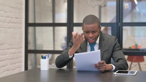 African Businessman Feeling Upset while Reading Contract Stock-Footage 301287410