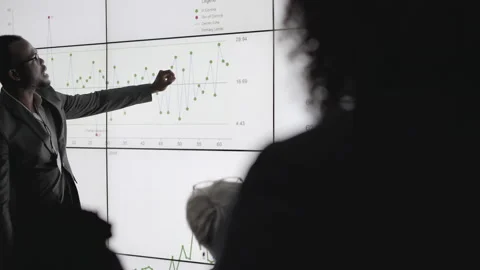 African businessman presenting data on a digital wall in an office Stock Footage 138983770