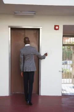 African businessman pushing elevator button Foto stock