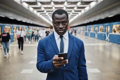 African businessman with smart phone at subway station Stock Photos