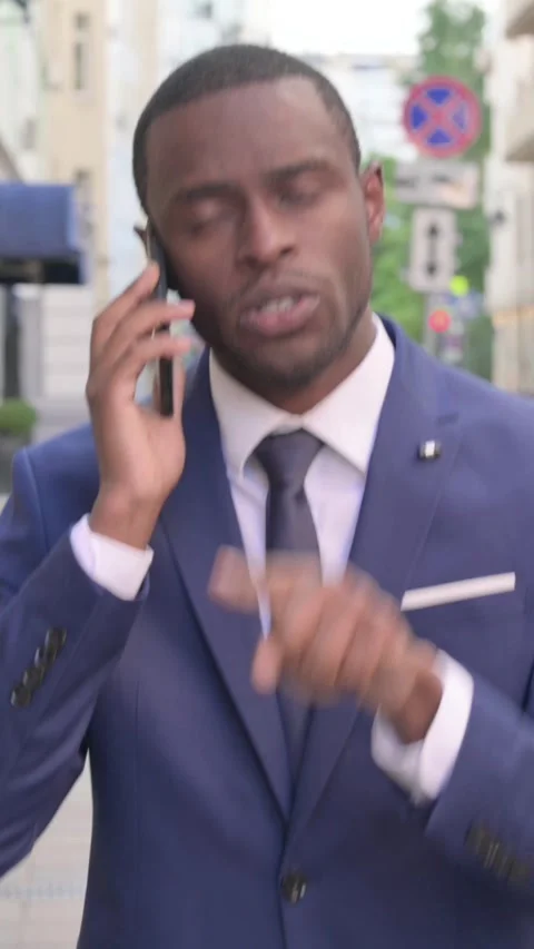 African Businessman Talking on Phone while Walking on Street, Vertical Video Stock Footage 340029627