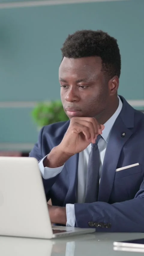 African Businessman Thinking while Working on Laptop in Office, Vertical Video Stock Footage 339574101