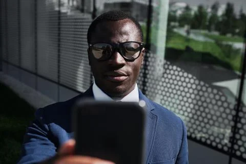African businessman using smart phone bus stop Stock Photos