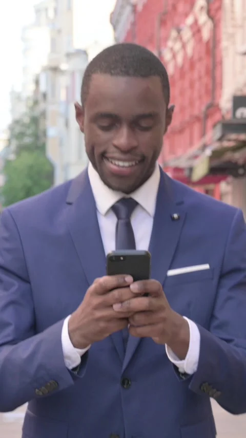 African Businessman Using Smartphone while Walking to Office, Vertical Video Stock Footage 340029123