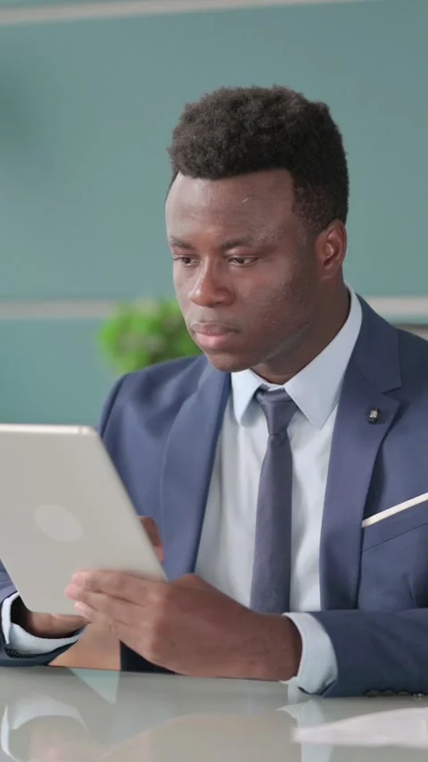 African Businessman using Tablet while Sitting in Office, Vertical Video Stock-Footage 339574982