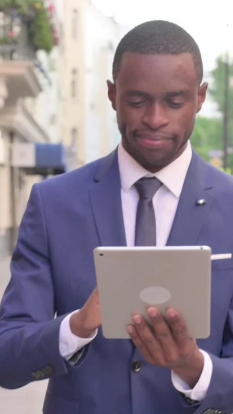 African Businessman Working on Tablet while Walking on Street, Vertical Video 動画素材 340031629