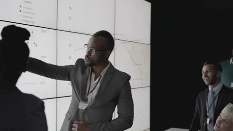 African businesspeople analyzing data during  multiscreen  wall presentation Stock Footage 138083636