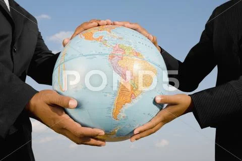 African businesspeople holding globe Stock Photos