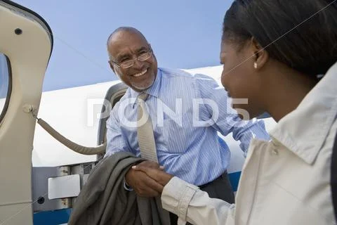 African businesswoman greeting arriving businessman Stock Photos